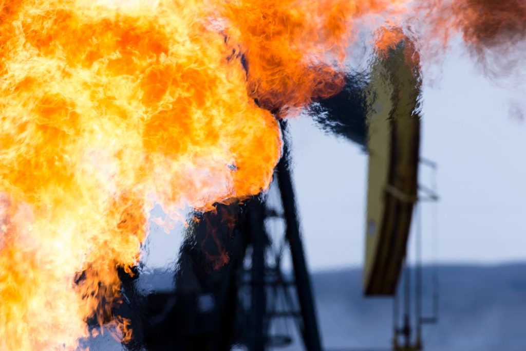 Methane gas flare and pump jack at an oil well in the Bakken Oil Fields, Mountrail County, North Dakota